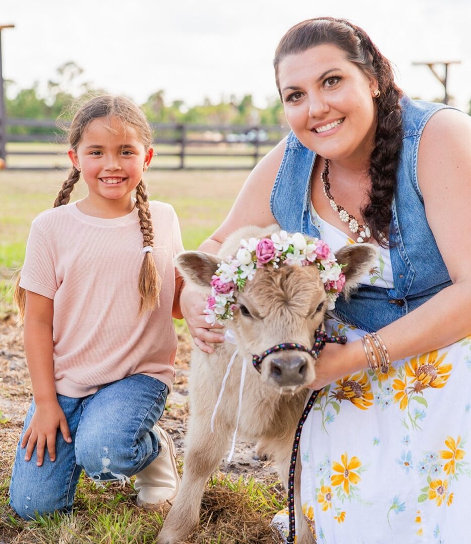 Child and adult petting decorated calf